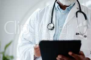 Diving into some medical research. Closeup shot of an unrecognisable doctor using a digital tablet in a medical office.