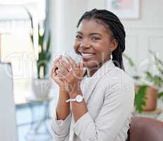 This warm brew soothes my soul. Shot of a beautiful young businesswoman enjoying a cup of coffee in her office.