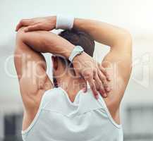 Rear view of unknown mixed race tennis player stretching arm and getting ready for court game. Hispanic fit athlete standing alone and holding stretch as warmup before match. Sporty man in sports club