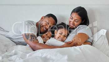 The type of heart that glows in the dark. a beautiful young family talking and bonding in bed together.