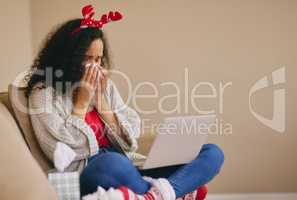 Christmas holidays spent alone hit hard. a young woman using a laptop and crying on the sofa during Christmas at home.
