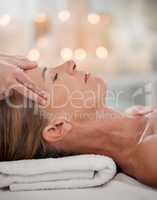 Let your worries simply float away. Shot of a woman receiving a temple massage at a spa.
