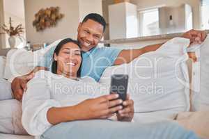 Dont just laugh alone, share so others can laugh with you. a woman using her cellphone while relaxing on the couch with her spouse.