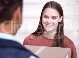 Ive been waiting forever. Shot of a woman accepting her delivery from the delivery man.