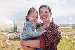 This farm is our home. a woman bonding with her daughter on a poultry farm.