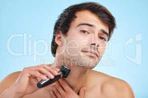 Beware of nicks and cuts. Shot of a young man shaving his face against a studio background.