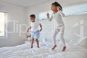 Happiness is having a close-knit family. Shot of an adorable little boy playing with his sister on a bed at home.