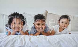 Brothers and sisters are as close as hands and feet. Shot of three siblings lying together in bed.