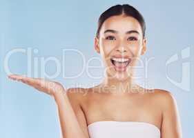 Beautiful young mixed race woman with copyspace. Attractive female endorsing your product in studio isolated against a blue background. The perfect marketing or ad space for your skincare range
