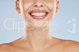 Closeup face beautiful young mixed race woman. Attractive female smiling in studio isolated against a blue background. Practising good oral and dental hygiene for healthy mouth, teeth and gums