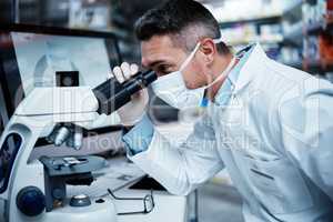 Making a difference in the healthcare industry. a mature man using a microscope while conducting pharmaceutical research.