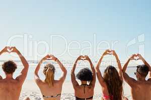 Spread love wherever you go. a group of friends with their hands in the air creating heart shapes.