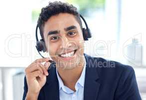 Portrait of one happy smiling mixed race call centre telemarketing agent talking on headset in office. Face of confident and friendly hispanic business man operating helpdesk for customer service and sales support