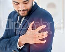 I have a sudden pain. Shot of a young businessman holding his shoulder in pain at work.