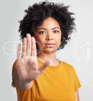 I object and want to voice my opinion. Studio shot of a woman gesturing to stop while standing against a grey background.
