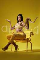 We could do it my way or we can do it the other way. Shot of a fashionable woman holding a snake while modelling a yellow concept.