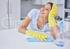 Dreaming of a futuristic self-cleaning home. a young woman smiling while cleaning a kitchen counter.