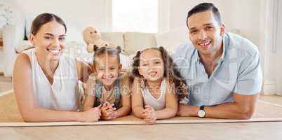 Togetherness is a very important ingredient to family life. a young couple bonding with their two young daughters at home.