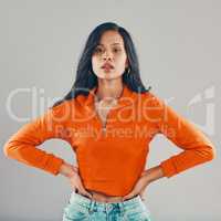 Portrait of mixed race woman isolated against grey studio background with copyspace and feeling flirty. Young, sultry, seductive hispanic standing alone. One model posing with confidence and attitude