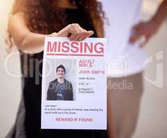 Bring back our loved ones. a woman holding a missing persons flyer.
