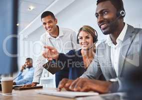 Happy caucasian female call centre telemarketing agent discussing plans with diverse colleagues while working together on computer in an office. Consultants troubleshooting solution for customer service and sales support