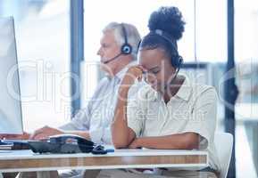 Why are some people so horrible on the phone. a young call centre agent looking stressed out while working in an office.