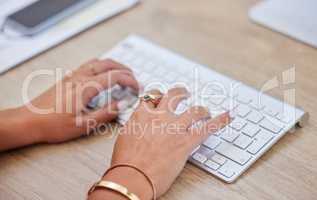 Closeup of one business womans hands and fingers typing on desktop computer keyboard at a table in an office. One female only sending emails while doing research and planning online for her startup