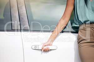 Close up of a unknown mixed race female standing and holding the handle of her new vehicle outside