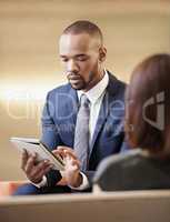 Business man working on his digital tablet. Young man using his business tablet during a business meeting