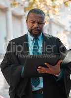 Reading up a bit more. a mature male lawyer preparing for court in the city.