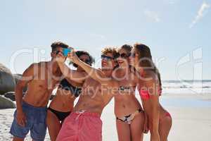 Say cheese for me. a group of friends taking selfies on the beach.