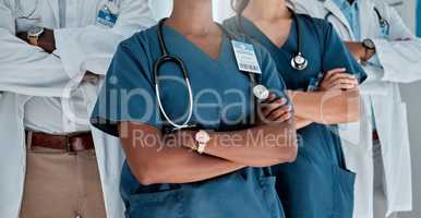 Group of doctors standing with their arms crossed while working at a hospital. Expert medical professionals standing at work together at a clinic