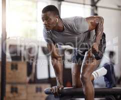 Serious african american athlete lifting dumbbell in tricep curl workout on bench in gym. Strong, fit, active black man training with weights in health and sport club. Weightlifting exercise routine