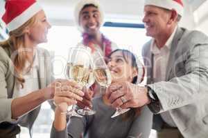 The end of the year is here. Shot of a group of business colleagues having a celebratory drink in an office.