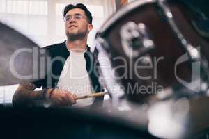 Drumming is life. a young drummer playing drums during a band practice at home.