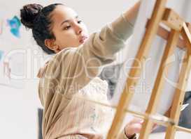 Letting the creativity flow. Low angle shot of an attractive young woman painting on a canvas in her studio.