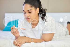 Am I finally going to be a mom or not. a young woman taking a pregnancy test at home.