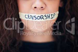 Censorship is cowardice. Closeup shot of an unrecognisable woman with tape on her mouth that has the word censorship written on it.