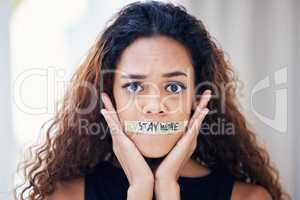 Its best to be radically aware than blissfully ignorant. Portrait of a young woman with tape on her mouth that has the words stay woke written on it.