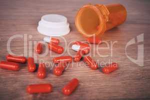 An open orange of brightly coloured pills spilled onto a wooden table. Vitamin supplements are a good way to maintain your health. Chronic or prescription medication are usually covered by medical aid