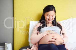 I cant wait to spoil you when you arrive. a pregnant woman relaxing at home.