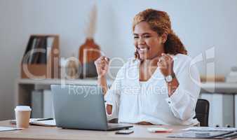 Happy and cheerful mixed race business woman cheering while working on a laptop in office. Confident hispanic female boss smiling while celebrating a victory or reading loan approval email