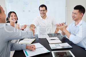 We are thrilled by this merger. Shot of businesspeople shaking hands during a meeting in an office.