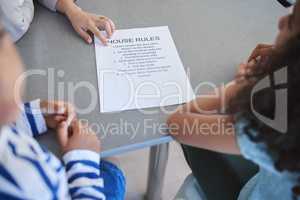 Structure training. Shot of an unrecognizable woman explaining a list of chores to her kids at home.