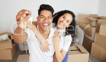 Weve unlocked another achievement. Shot of a young couple holding a key to their new house.