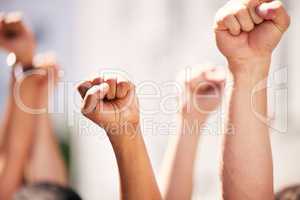 Fighting the dominant power. a group of people with their fists raised at a protest.