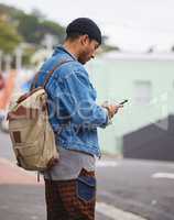 Which direction should be heading towards. a young man using a phone in the city.