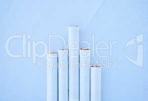 Five different length cigarettes lined up against a blue background in studio. Nicotine addiction can have a variety of levels depending on how much you smoke. The tobacco industry is market dependant