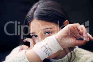 Save me from myself. a young woman with bandages wrapped around her wrists showing help written on them.