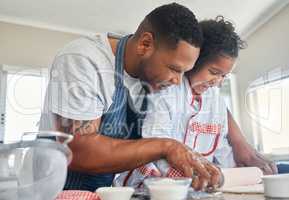 Baking can be an opportunity to connect. Shot of a father baking with his daughter at home.